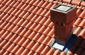 An image of a clay roof with a small chimney