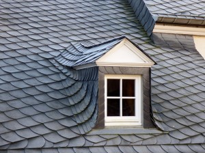 An image of a slate roof with a small window