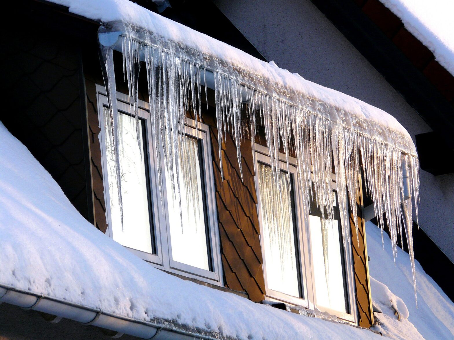 A window with ice stalactite hanging from the roof