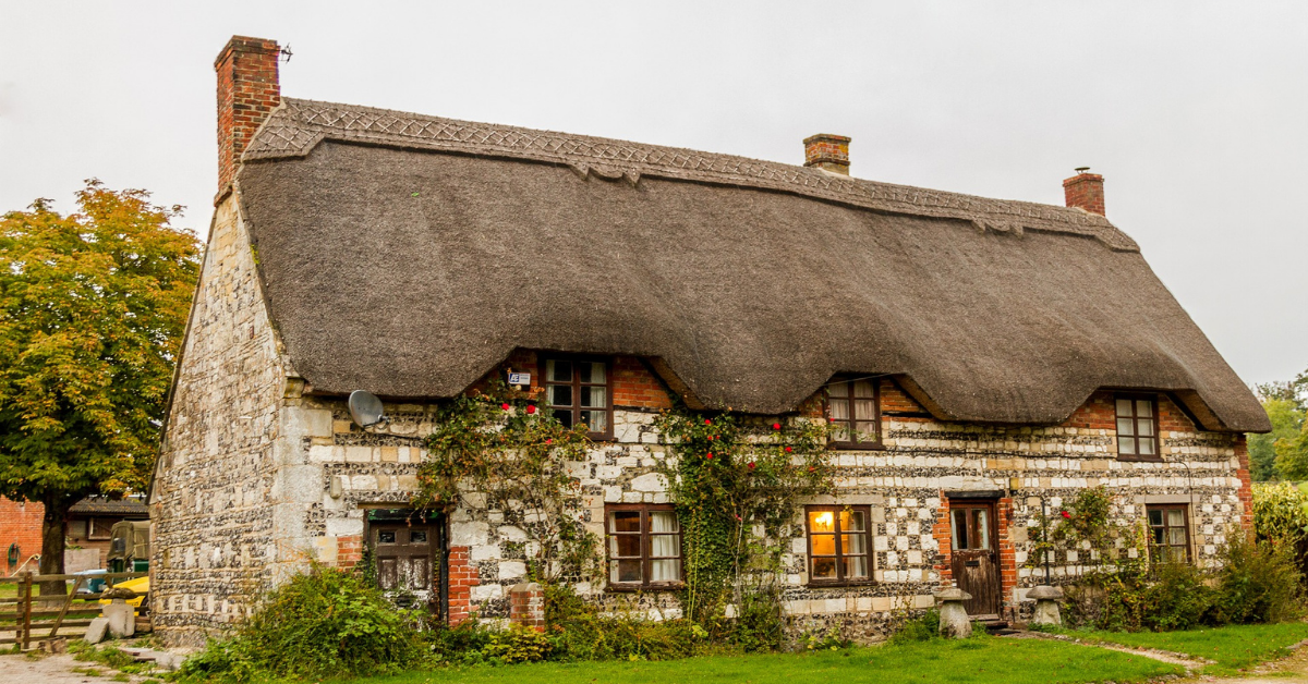An image of a large house with a thatched roof